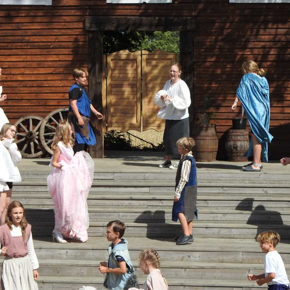 Deltagare i kostym på scenen i Öja